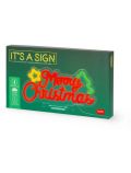 В зелена кутия е показан Лампа Legami It's A Sign - Merry Xmas неонов ефект LED табела с червен надпис "Merry Christmas", звезди и форми на дървета. На опаковката са показани икони, информация за продукта и марката Legami в долния десен ъгъл.