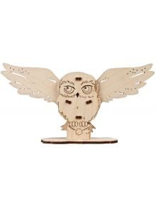 3D дървен пъзел Ugears Хари Потър - Хедуиг, 9 части е модел на снежна сова с разперени крила и лазерно изрязани детайли за очи, пера и човка. Стои върху плоска основа и е незавършен, неподплатен.
