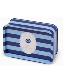 Правоъгълна тенекиена кутия със сини ивици съдържа ароматна свещ Paddywax - опушено, тамянов аромат, 6.5oz, с кръгъл етикет и око - идеална за ароматно пътешествие до Средиземноморието.