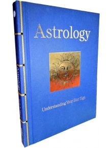Синя книга с твърди корици, озаглавена "Астрология": със златна илюстрация на лицето на слънцето на предната корица и златни декоративни акценти на гръбнака.