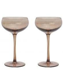 Две елегантни The Lou Coupe чаши за коктейл с широки, плитки чаши и дълги, тънки дръжки стоят една до друга на бял фон. Предлагат се в книжарница Orange.