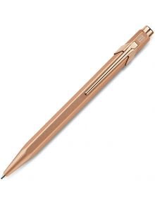 Метален розовозлатен пистолет Caran d'Ache 849 химикалка с клипс и шестоъгълна цев, наличен в книжарница Orange, показан на бял фон.