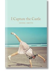 Момиче с розова рокля и бели маратонки прави колело на пясъчен плаж с океана зад гърба си. В горната част на изображението е изписано заглавието "Аз превземам замъка (Macmillan Collector's Library).