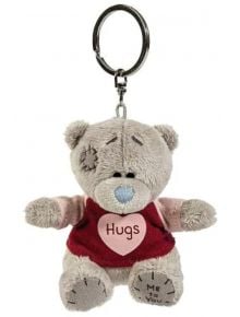 Ключодържател To You - Hugs е плюшен ключодържател Tatty Teddy със сива козина, син нос и червена риза с розово сърце и надпис "Hugs". То е с прошити детайли и надпис "Me to You" (Аз за теб) на лявото му краче - очарователен подарък.