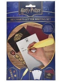 Предна част на Комплект за писане с перо Blue Sky Хари Потър, показан с пликове, листове за писма, жълто перо и лист със стикери на тема Хогуортс. Ръката пише върху писмо с помощта на перото с пера.