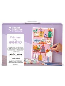 В кутия с надпис Комплект за рисуване по номера Graine Creative - Кухненски кът 20 x 30 см. са показани кухненски рафтове със съдове, растения и прибори. Една ръка оцветява картина по номера Peinture au numéro Côté Cuisine.