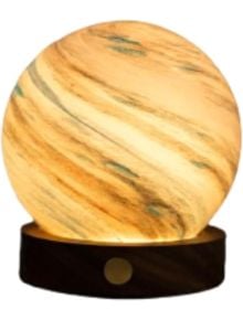 Настолна лампа Gingko AstraGlass Light Mini Polar Cloud има сферичен, мраморен жълто-кафяв нюанс на ръчно издухано стъкло върху тъмна дървена основа, излъчващ топла, мека светлина, напомняща малка планета.