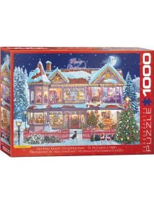 Пъзел Eurographics - Подготовка за Коледа, 1000 части показва празнична заснежена къща с коледни светлини, семейства, подготвящи се за празника, украсено дръвче до прозореца и деца, които играят пред червената ограда.