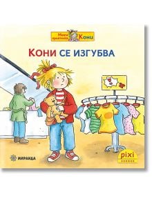 Момиче, което държи плюшено мече, стои притеснено в магазин за дрехи с пъстри дрехи наблизо. Друг човек е на касата. Текстът е на български език и включва героинята Кони от "Pixi 30: Кони се изгубва".