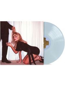 Жена с черен костюм и токчета позира на четири крака, а някой извън кадър държи русата ѝ коса. На заден план се виждат бели завеси и мокет, а до нея частично се вижда Sabrina Carpenter - Man's Best Friend (VINYL).