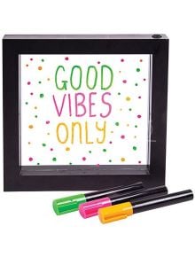 Светеща неонова рамка за съобщения Fizz Creations показва позитивно послание GOOD VIBES ONLY в зелено, розово и жълто, с цветни точки наоколо. Пред рамката са подредени три цветни маркера.