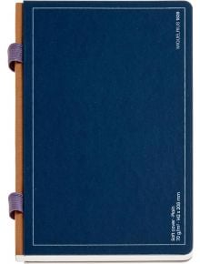 Затвореният Тефтер Miquelrius B2B Doble Azul A5 с комбинирано съдържание има синя твърда корица, кафяв гръбнак и две лилави ластични ленти отляво, разположени на бял фон. В долния десен ъгъл на корицата се появява бял текст.