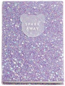 A лилав тефтер Miquelrius Back2Fun Spark Away с твърди брокатени корици и полупрозрачен етикет с надпис SPARK AWAY във формата на мече на корицата.
