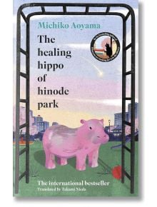 Корица на книгата "Лечебният хипопотам от парка Хиноде", на която е изобразен розов хипопотам в парк с детска площадка, дървета и градски сгради - идеален избор за читатели, които обичат емоционална литература.