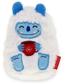 Плюшено бяло и синьо карикатурно йети с голяма усмивка, сини уши и крака, което държи Legami SOS Йети чаша за затопляне на ръце, украсена с червена снежинка за многократна употреба.